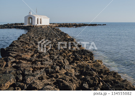 Iconic coastal chapel near Georgioupolis surrounded by blue waters 134555082