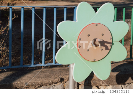 Colorful floral water faucet on a playground, providing a source of water for kids 134555115