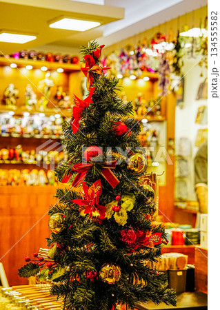 Small Decorated Christmas Tree with Red Bows and Ornaments in Shop Window Small Decorated Christmas Tree with Red Bows and Ornaments in Shop Window 134555582