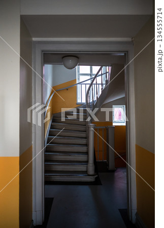 Vintage apartment stairwell with curved staircase and yellow walls Vintage apartment stairwell with curved staircase and yellow walls 134555714