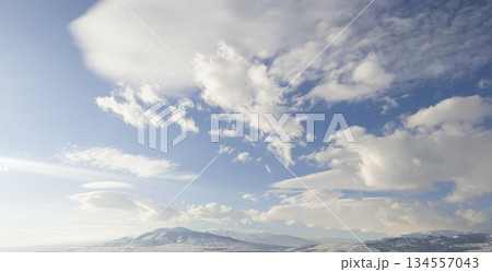 Aerial view snow covered mountains. Snowy mountain ridge on winter sunrise. Stunning mountains range covered with snow 134557043
