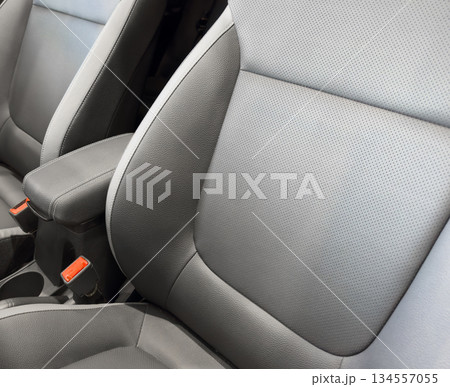 Modern luxury car black leather interior. Part of black leather car seat details with white stitching. Interior of prestige car. Comfortable perforated leather seats. Perforated leather. Modern luxury car black leather interior. Part of black leather car seat details with white stitching. Interior of prestige car. Comfortable perforated leather seats. Perforated leather. 134557055