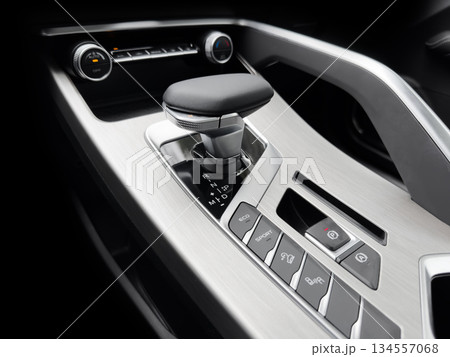 Automatic gear stick of a modern car. Modern car interior details. Close up view. Car inside. Automatic transmission lever shift. Black leather interior with stitching 134557068