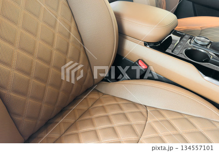 Modern luxury car white leather interior. Part of white leather car seat details with white stitching. Interior of prestige car. Perforated leather seats isolated. Perforated leather. Modern luxury car white leather interior. Part of white leather car seat details with white stitching. Interior of prestige car. Perforated leather seats isolated. Perforated leather. 134557101