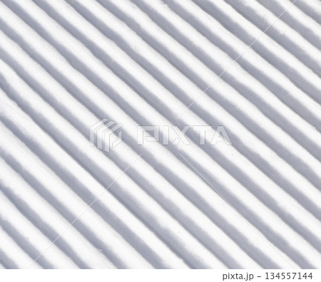 Close up of groomed tracks on a slope in a downhill ski resort. Close-up straight line rows of freshly prepared groomed ski slope 134557144