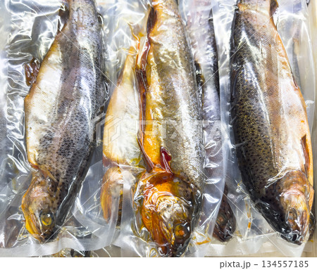 Vacuum packaged smoked rainbow trout fish isolated on white background. 134557185
