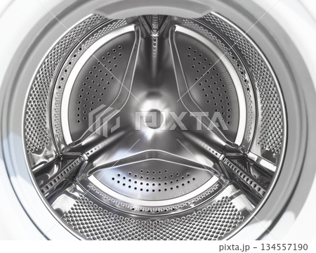 Washing machine drum close up. Washing machine background. Inside the washing machine. Metal washing machine drum. Perforated shiny metal 134557190