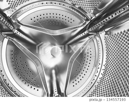 Washing machine drum close up. Washing machine background. Inside the washing machine. Metal washing machine drum. Perforated shiny metal 134557193