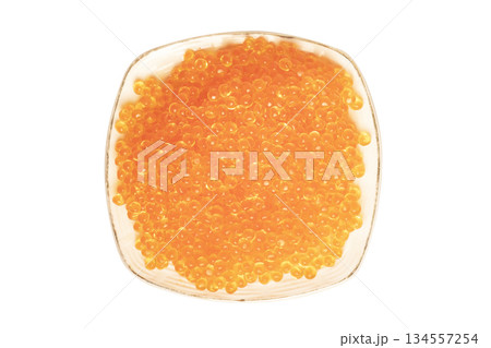 Red caviar in the ceramic plate isolated on a white background. Trout or salmom caviar close up. Macro shot. Top view Red caviar in the ceramic plate isolated on a white background. Trout or salmom caviar close up. Macro shot. Top view 134557254
