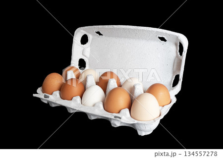 Egg tray with fresh brown eggs isolated on black background. Fresh organic chicken eggs in carton box. Egg tray with fresh brown eggs isolated on black background. Fresh organic chicken eggs in carton box. 134557278
