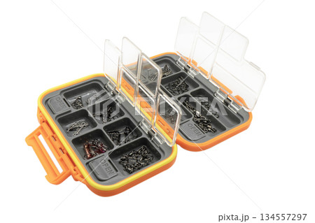Opened tackle box with fishing hooks and accessories. Fishing hooks in box sections. Case for tackle elements. Fishing accessories background close-up. Opened tackle box with fishing hooks and accessories. Fishing hooks in box sections. Case for tackle elements. Fishing accessories background close-up. 134557297