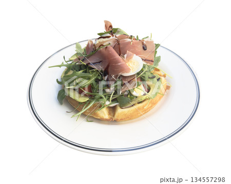 Breakfast time. Waffle with prosciutto, salad and egg for breakfast isolated on white background. Breakfast time. Waffle with prosciutto, salad and egg for breakfast isolated on white background. 134557298