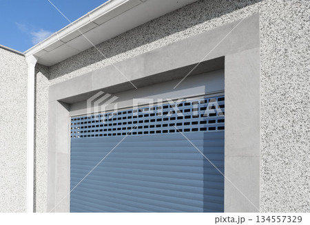 Roller shutter gate. Metal roller garage door as background. Automatic electric roll-up garage gate. Garage with blue rolling gates. Roller shutter gate. Metal roller garage door as background. Automatic electric roll-up garage gate. Garage with blue rolling gates. 134557329
