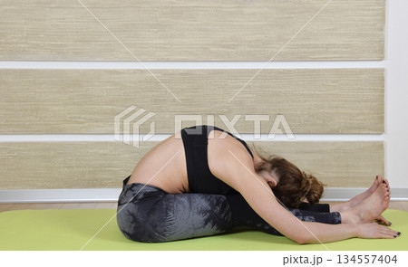Young woman doing yoga in living room. Yoga poses for exercise and meditation. Exercise for a healthy body. Yoga concept. Young woman doing yoga in living room. Yoga poses for exercise and meditation. Exercise for a healthy body. Yoga concept. 134557404