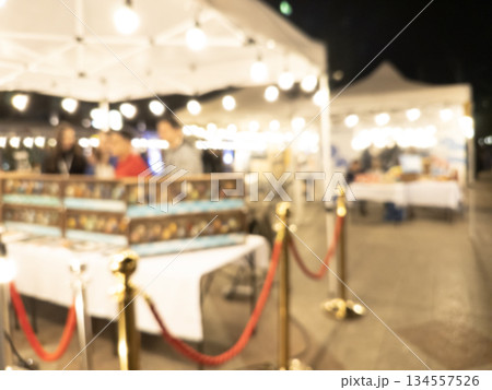 Blurry market fair environment around shopping community and market place at night. Blurred fair background texture with bokeh lights Blurry market fair environment around shopping community and market place at night. Blurred fair background texture with bokeh lights 134557526