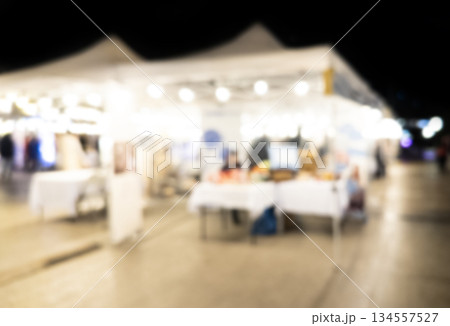 Blurry market fair environment around shopping community and market place at night. Blurred fair background texture with bokeh lights 134557527