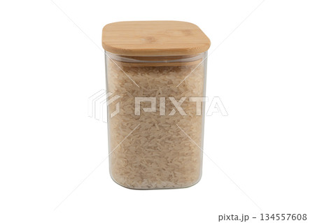 Rice in a glass jar isolated on a white background. Raw white organic rice grains in glass storage jar isolated. Rice in a glass jar isolated on a white background. Raw white organic rice grains in glass storage jar isolated. 134557608