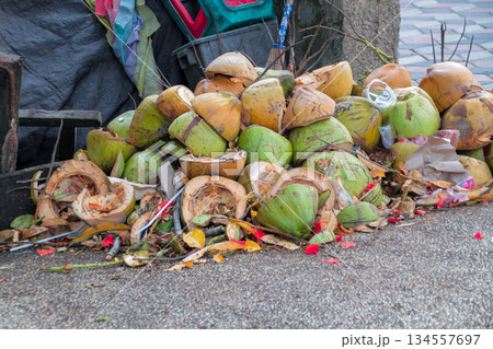 Close-up view of tropical street waste featuring a dense accumulation of cut coconut shells and residual organic matter. Close-up view of tropical street waste featuring a dense accumulation of cut coconut shells and residual organic matter. 134557697