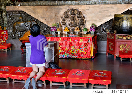 Worshiper praying in the historic Buddhist Jingan Temple on the West Nanjing Road in downtown Shanghai, China 134558714