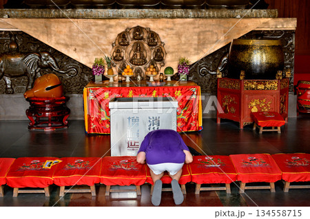 Worshiper praying in the historic Buddhist Jingan Temple on the West Nanjing Road in downtown Shanghai, China Worshiper praying in the historic Buddhist Jingan Temple on the West Nanjing Road in downtown Shanghai, China 134558715