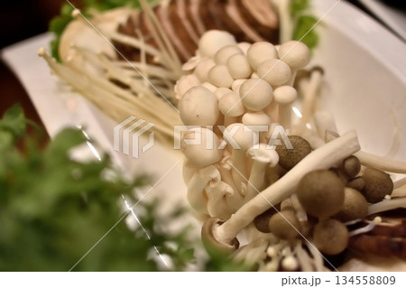 Close-up of assorted mushrooms on a plate, with enoki and shimeji 134558809