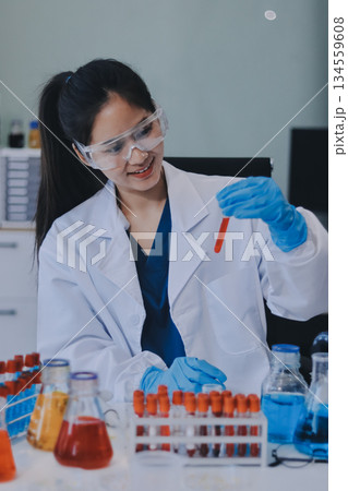 Portrait, science and happy woman on laptop in lab to research chemistry, test or innovation. Microscope, scientist and face of medical doctor in goggles for microbiology, healthcare or pharma study 134559608