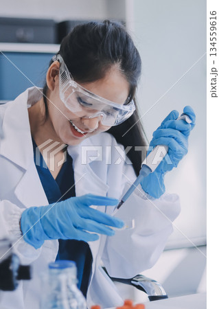 Portrait, science and happy woman on laptop in lab to research chemistry, test or innovation. Microscope, scientist and face of medical doctor in goggles for microbiology, healthcare or pharma study 134559616