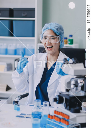 Portrait, science and happy woman on laptop in lab to research chemistry, test or innovation. Microscope, scientist and face of medical doctor in goggles for microbiology, healthcare or pharma study 134559645