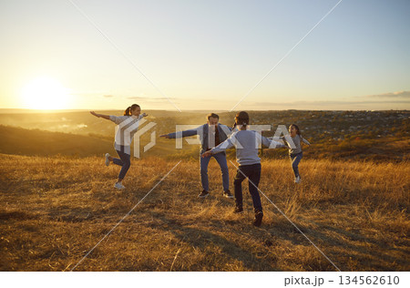 Blindfolded child boy catching his family playing hide and seek together outdoors. 134562610