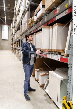 Man choosing furniture in warehouse store Man choosing furniture in warehouse store 134565112
