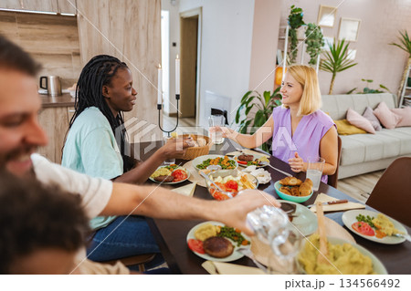 Friends enjoying a homemade meal at the table 134566492