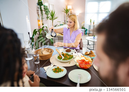 Gathering around a table enjoying a healthy meal together 134566501