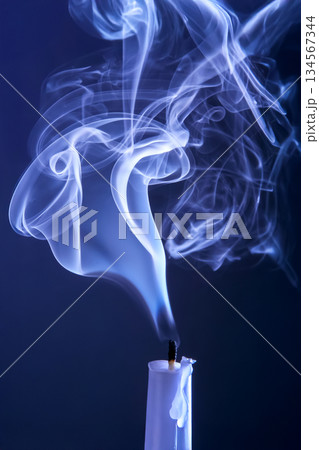 Smoke from an extinguished candle on a dark background. Smoke from an extinguished candle on a dark background. 134567344