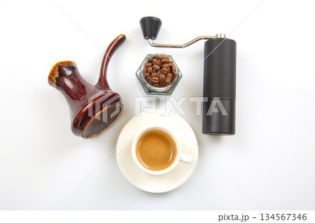 A black manual coffee grinder, a ceramic cezve with a wooden handle 134567346