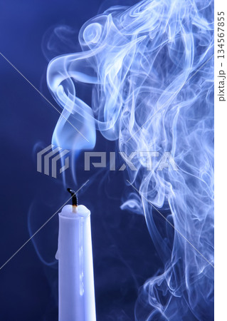 Smoke extinguished candle on a dark background. The concept of spirituality and the end of life. Smoke extinguished candle on a dark background. The concept of spirituality and the end of life. 134567855