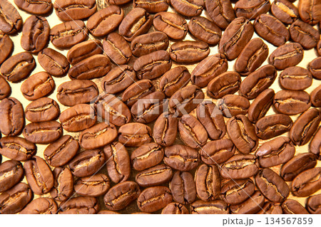 Stunning macro photography of roasted coffee beans on a shiny golden background, Stunning macro photography of roasted coffee beans on a shiny golden background, 134567859