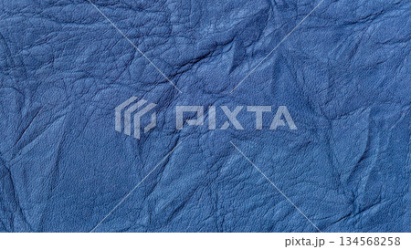Close-up of wrinkled blue leather texture with natural grain and creases. Natural accessory background, fashion design, trendy color, copy space Close-up of wrinkled blue leather texture with natural grain and creases. Natural accessory background, fashion design, trendy color, copy space 134568258