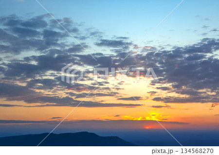 Beautiful sky at sunset with warm golden hues reflecting off scattered clouds. Beautiful sky at sunset with warm golden hues reflecting off scattered clouds. 134568270