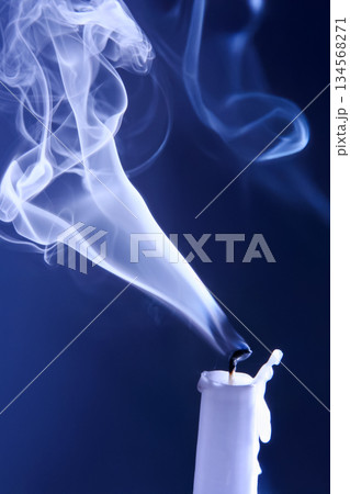Smoke extinguished candle on a dark background. The concept of spirituality and the end of life. Smoke extinguished candle on a dark background. The concept of spirituality and the end of life. 134568271