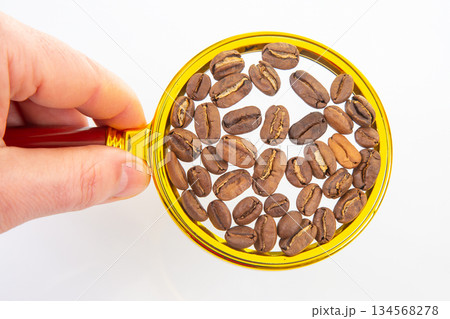 roasted coffee beans on a magnifying glass on a white background 134568278