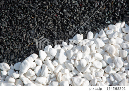 a striking contrast between smooth white pebbles and dark black gravel, a striking contrast between smooth white pebbles and dark black gravel, 134568291