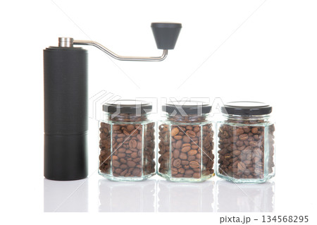 black manual coffee grinder for coffee beans and three glass transparent jars with black lids 134568295