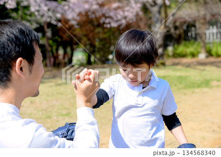 上手にできた子どもを褒める父親　ハイタッチ　公園でキャッチボールする親子　 134568340