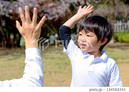 上手にできた子どもを褒める父親 ハイタッチ 公園でキャッチボールする親子 上手にできた子どもを褒める父親 ハイタッチ 公園でキャッチボールする親子 134568341