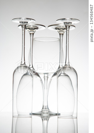 Crystal wine glasses in various shapes stand tall, their reflections doubling on a sleek surface 134568487