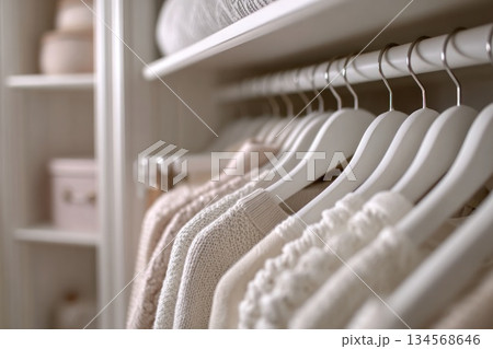 Elegant closet organization featuring soft knitwear and pastel accessories Elegant closet organization featuring soft knitwear and pastel accessories 134568646