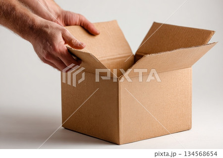Unpacking a cardboard box in a well lit indoor setting 134568654