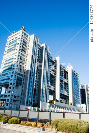 真っ青な青空の下のガラス張りと球形の部分が付いた近代的な建物　東京都のお台場にて 134568774