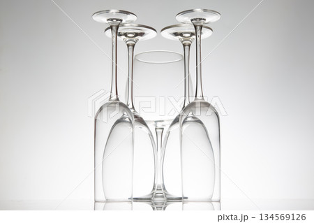 Crystal wine glasses in various shapes stand tall, their reflections doubling on a sleek surface 134569126