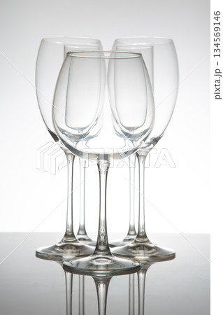 Elegant wine glasses with long stems and clear bowls, arranged in a line 134569146